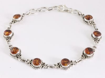 Bewerkte zilveren schakelarmband met amber
