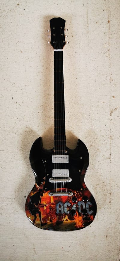 Gitaar Miniatuur 25 cm hoog - ACDC - 12 - Mini gitaartje op standaard - Muziek accessoires - Mancave - Girlcave - Decoratie - Mini - Collectable - Cadeau - Miniature - Muzikanten en muziekliefhebbers