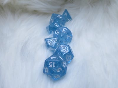 Polyset Dice | Dobbelstenen - Set Van 7 Stuks - Licht Blauw Glitters Wit Doorzichtig Transparant| Voor D&D en Andere Rollenspellen | Plastic Dobbelstenen Set voor Dungeons and Dragons | Polyhedral Dice Set | Mooie Zwarte Velvet Dice Bag voor 3 Sets