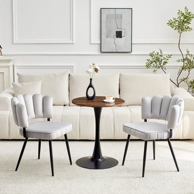 Tafel- en stoelenset. Ronde tafel van 60 cm van MDF met zwarte steunpoot, gecombineerd met 2 lichtgrijze eetkamerstoelen met fluweelbeklede rugleuningen in de vorm van bloemblaadjes en zwarte metalen poten.