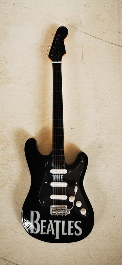 The Beatles Miniatuur Gitaar ST Model – Houten Pop Rock Decoratie met Standaard – Luxe Merseybeat Band Merchandise – 25 cm Hoog – Uniek Cadeau Muziekliefhebber