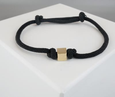 Zwarte armband met gouden kubus