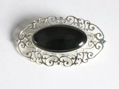 Opengewerkte zilveren broche met onyx