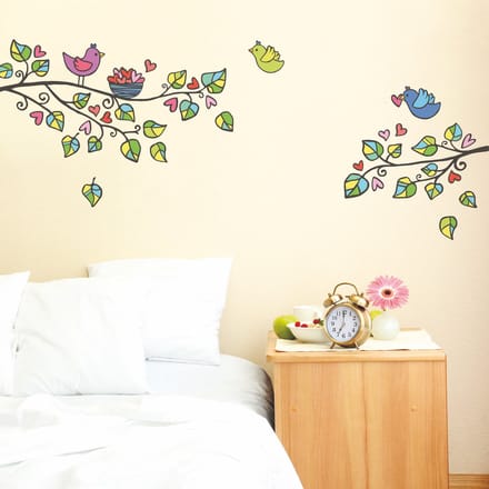 Decoratieve muurstickers met bomen, vogels en hartjes.