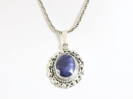 Bewerkte zilveren hanger met blauwe saffier aan ketting