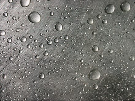 Fotobehang - Stalen oppervlak met water druppels.