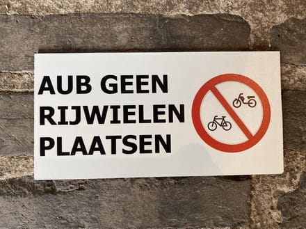 Tekstbordje met de tekst AUB geen rijwielen plaatsen
