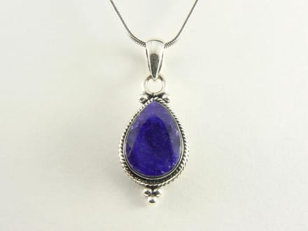 Bewerkte zilveren hanger met blauwe saffier aan ketting