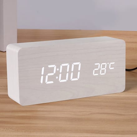 Witte houtafwerking. Digitale wekker met duidelijke led-cijfers en temperatuurweergave.