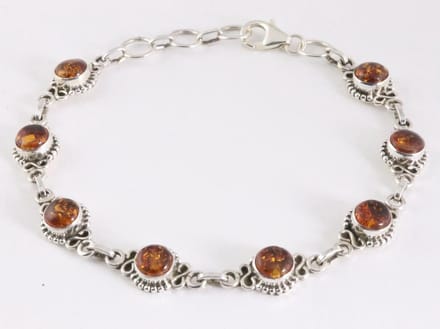 Bewerkte zilveren schakelarmband met amber