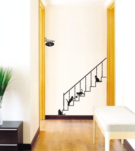 Decoratieve muurstickers met katten en trappen.