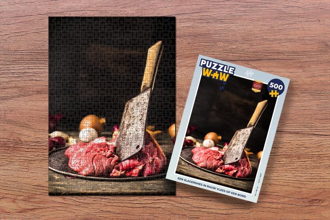 Puzzel Een slagersmes in rauw vlees op een bord - Legpuzzel - Puzzel 500 stukjes