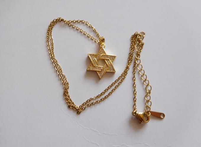 Ketting met hanger Davidster goudkleur met steentjes.