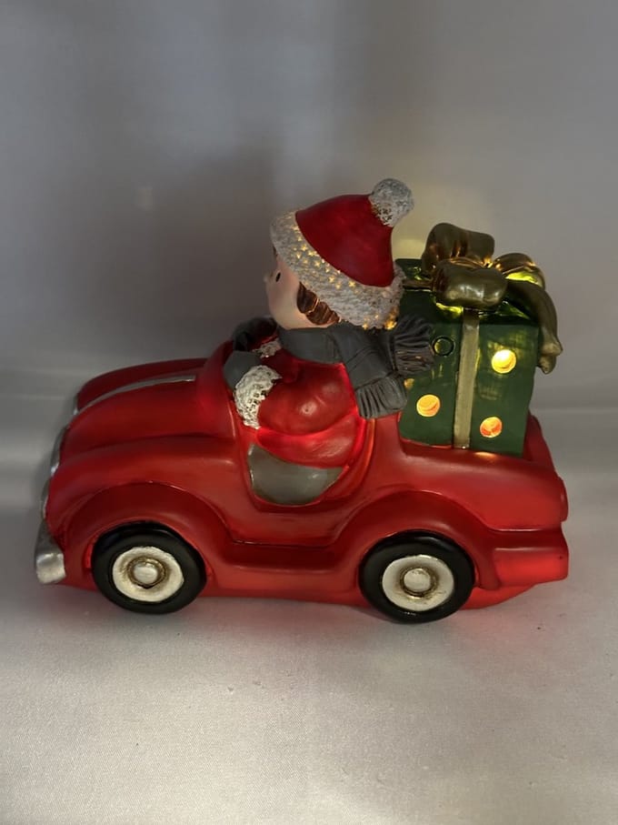 Kerstbeeldje jongen in rode auto met LED - groene cadeau - polyresin - 12 cm hoog x 16 cm x 8 cm – Kerstdecoratie