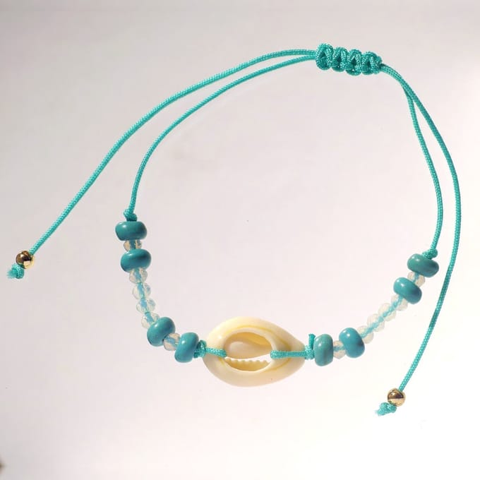 Turquoise armband met kauri schelp, glitteraccenten en zilverkleurige details
