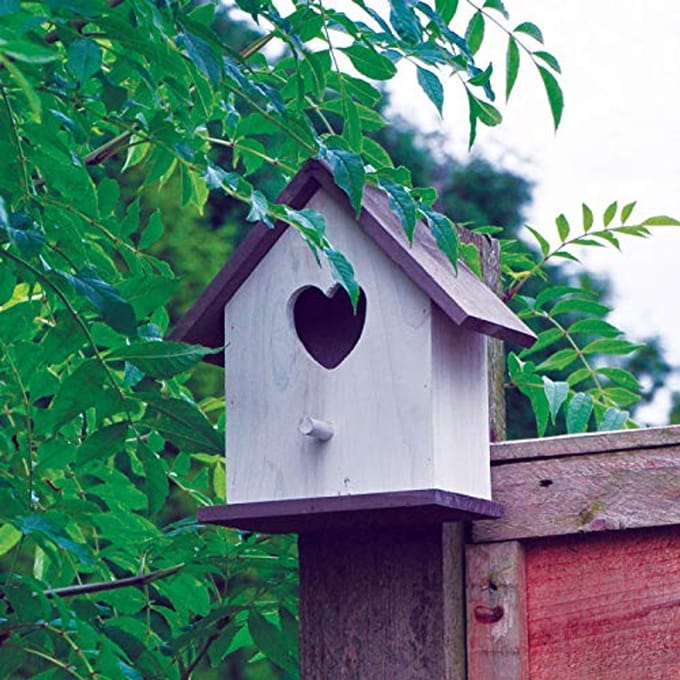 Groot witte houten vogelhuis met hartvormige ingang voor kleine tuinvogels