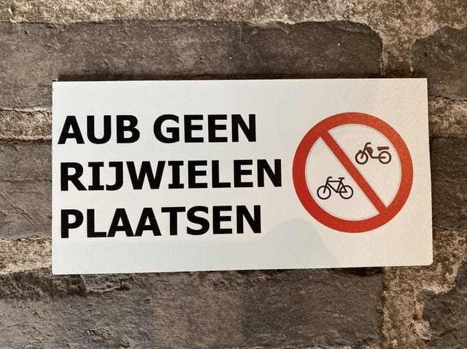 Tekstbordje met de tekst AUB geen rijwielen plaatsen