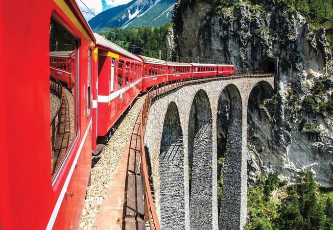 Fotobehang Train Through The Mountains | XL - 208cm x 146cm | 130g/m2 Vlies