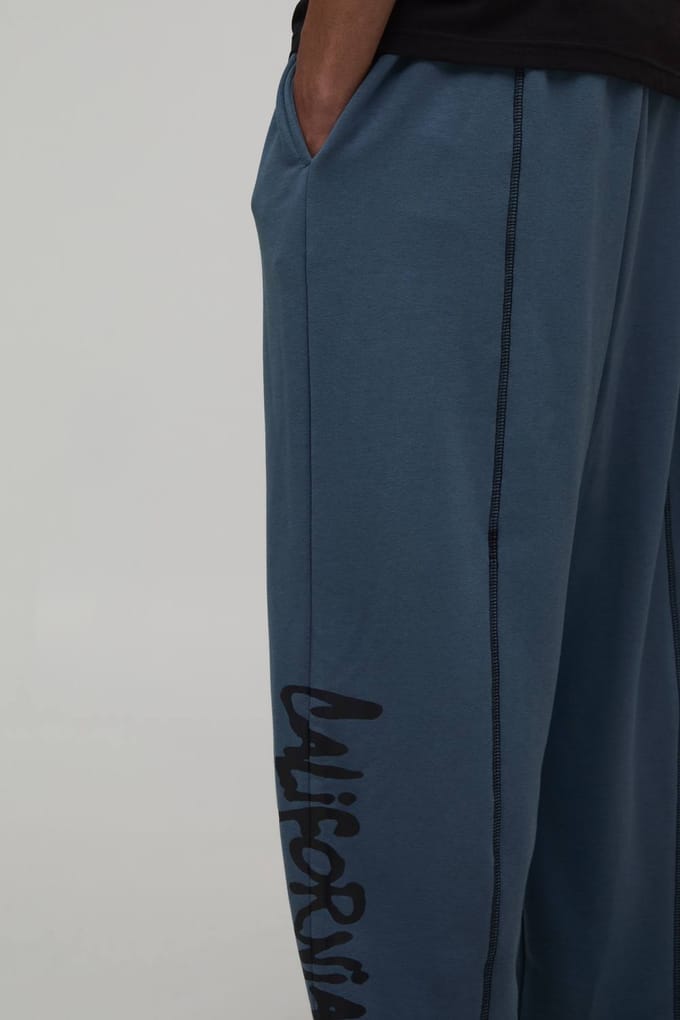 Balloon Fit Joggingbroek Met Contrasterende Stiksels En California Print In Loopback | Slate Blue | Size Medium