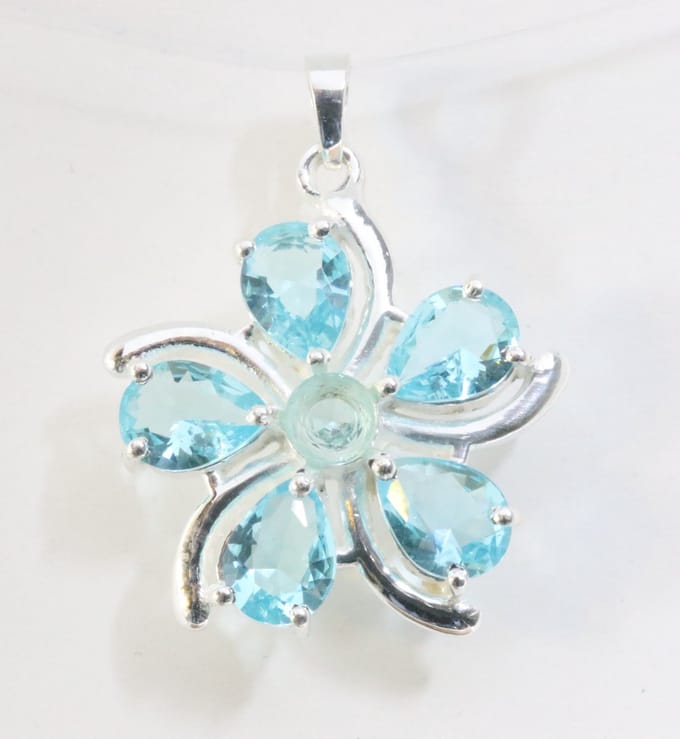 Bloemvormige zilveren hanger met blauwe topaas