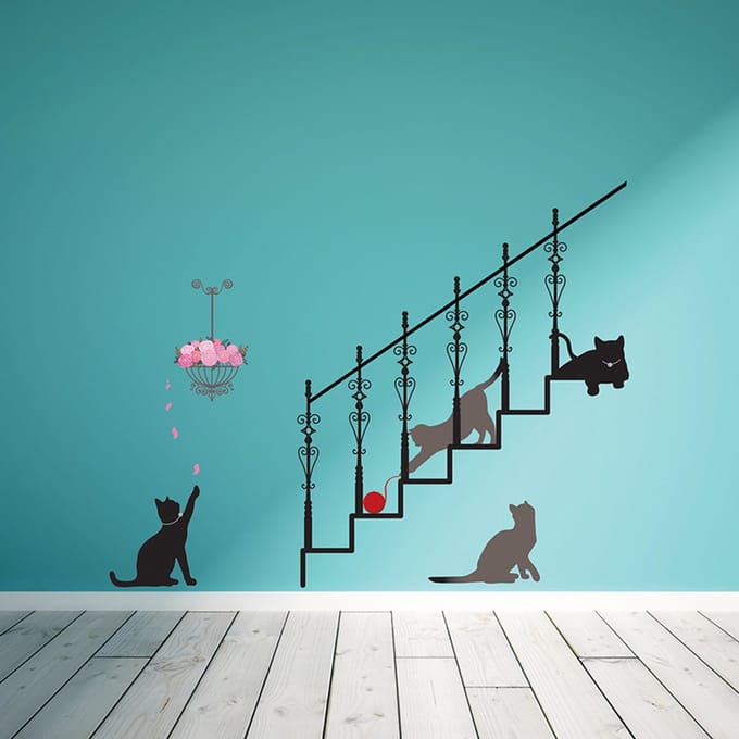 Decoratieve muurstickers met afbeeldingen van katten, trappen en rozenblaadjes.