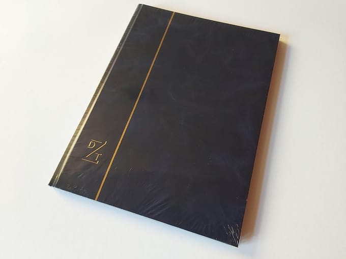 Dezittere postzegelalbum 32 zwarte bladzijden blauwe kaft