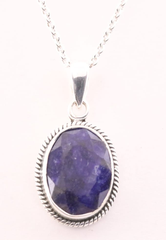 Bewerkte zilveren hanger met blauwe saffier aan ketting