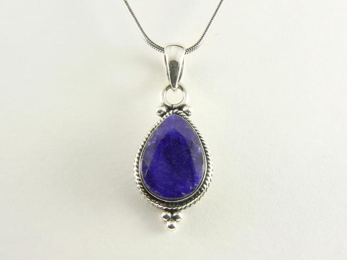 Bewerkte zilveren hanger met blauwe saffier aan ketting