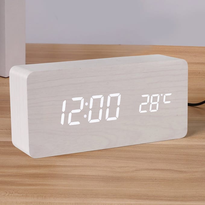 Witte houtafwerking. Digitale wekker met duidelijke led-cijfers en temperatuurweergave.