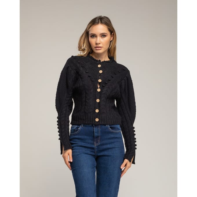 Gehaakt vest met pompons en bloemendetails.
