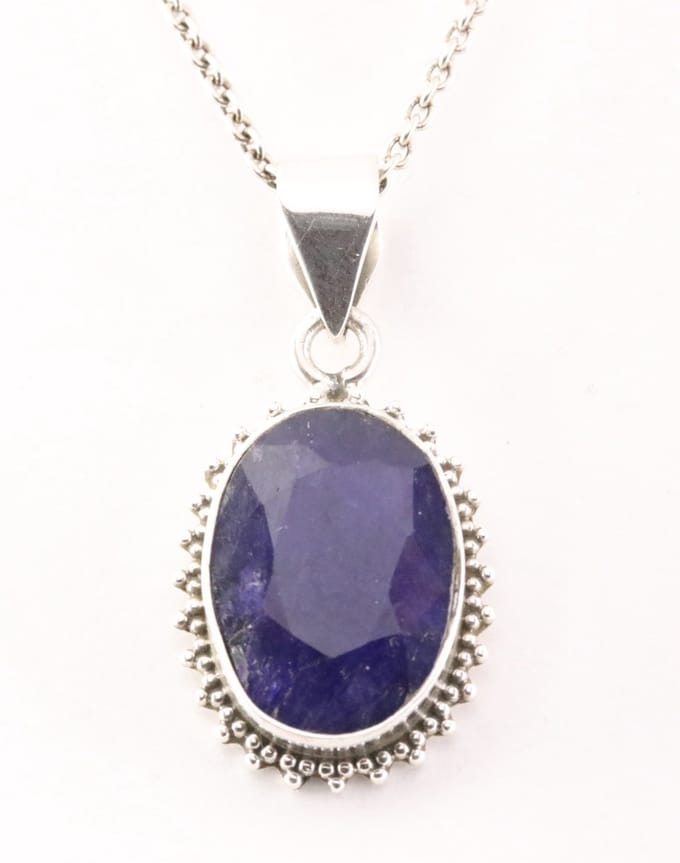 Bewerkte zilveren hanger met blauwe saffier aan ketting