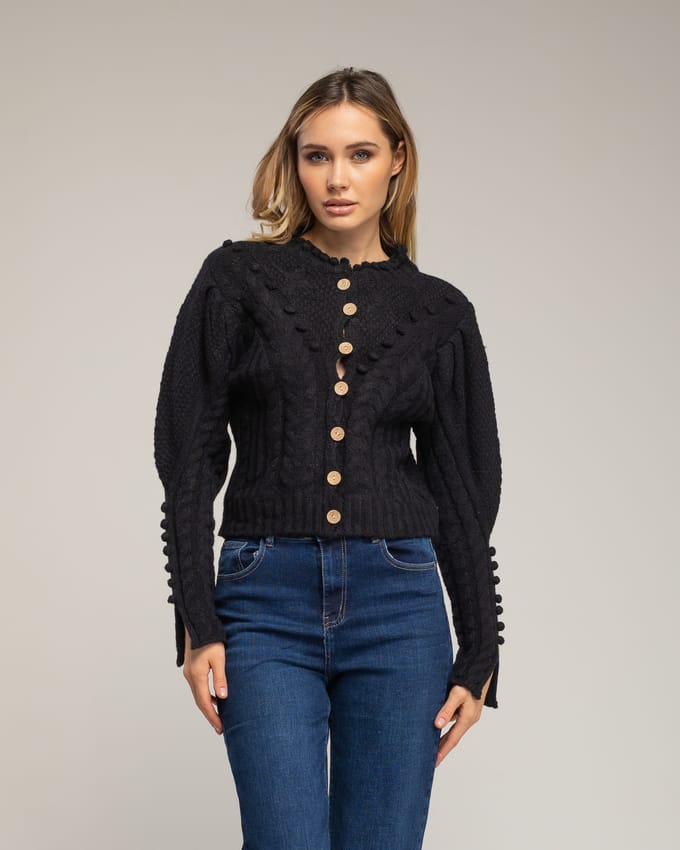 Gehaakt vest met pompons en bloemendetails.