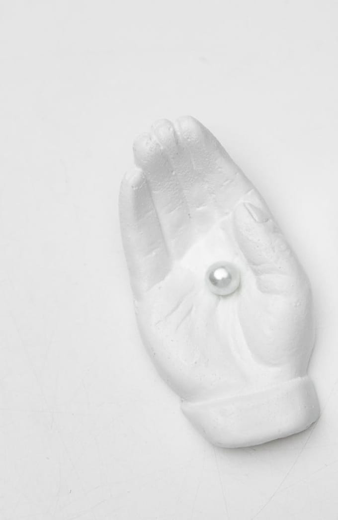 Beeld hand met parel wit