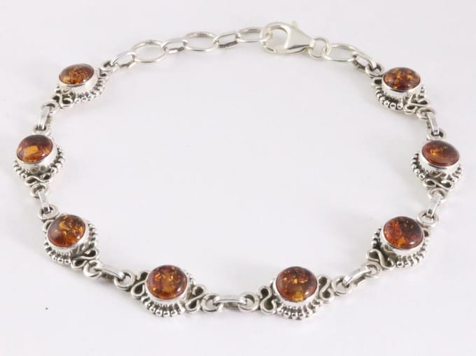Bewerkte zilveren schakelarmband met amber