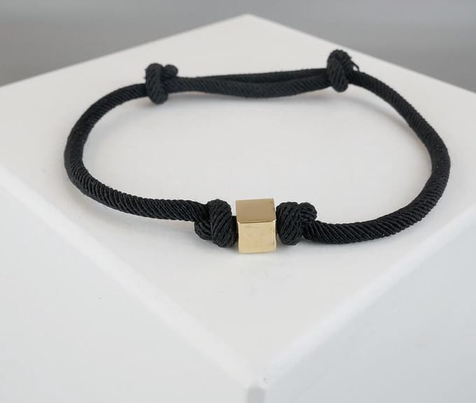 Zwarte armband met gouden kubus