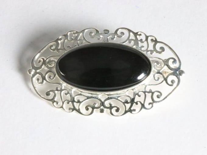 Opengewerkte zilveren broche met onyx