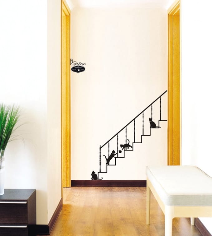 Decoratieve muurstickers met katten en trappen.